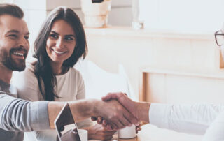 husband and wife shaking hands with an IT consultant