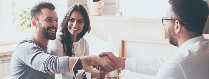 husband and wife shaking hands with an IT consultant