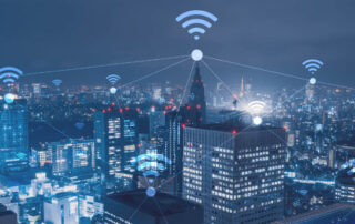 composite image of a city with wi-fi graphics glowing over buildings